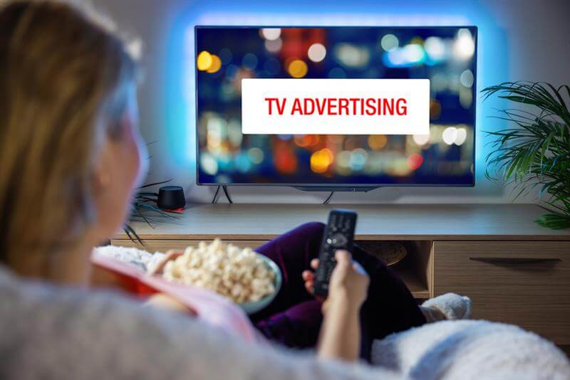 Woman watching tv commercials.
